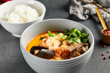 Tom yum soup with spicy seafood. Grey bowl on dark slate table. Thai, asian, authentic food concept