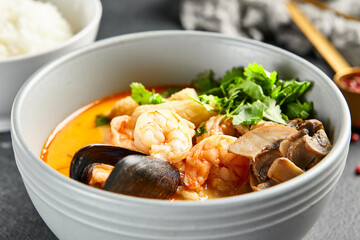 Tom yum soup with spicy seafood. Grey bowl on dark slate table. Thai, asian, authentic food concept