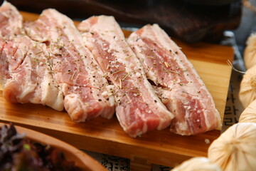 밑반찬과 생돼지고기가 있는 상차림 Table set with side dishes and raw pork