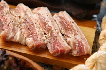 밑반찬과 생돼지고기가 있는 상차림 Table set with side dishes and raw pork
