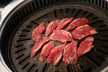 The beef ribs are being cooked on a black grill 검은색 불판에 소고기 갈비살이 익어가고 있는 모습