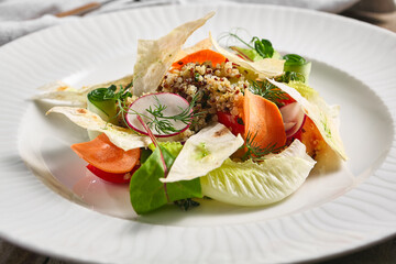 Quinoa Salad with Veggies. Restaurant vegetarian food plate on wooden table. Vegetables, healthy, organic dinner concept