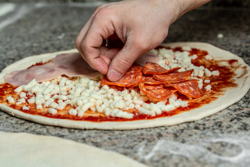 Hands preparing a pizza. The process of making pizza. Closeup hand of chef baker making pizza at kitchen