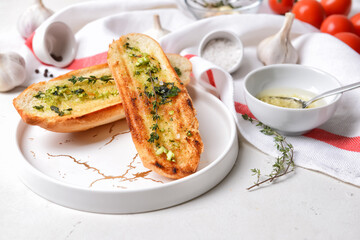 Toasted bread and garlic on light background