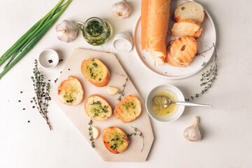 Toasted bread and garlic on light background