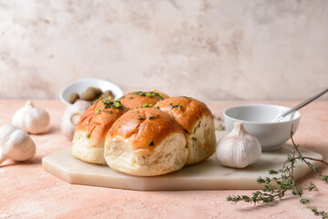 Fresh bread and garlic on light background