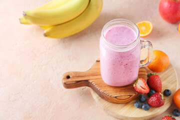 Mason jar of tasty berry smoothie on color background