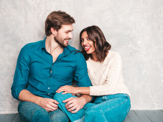 Smiling beautiful woman and her handsome boyfriend. Happy cheerful family having tender moments near grey wall in studio.Pure cheerful models hugging.Embracing each other