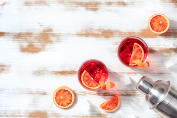 Orange cocktails with blood oranges and a shaker, overhead flat lay shot with a place for text
