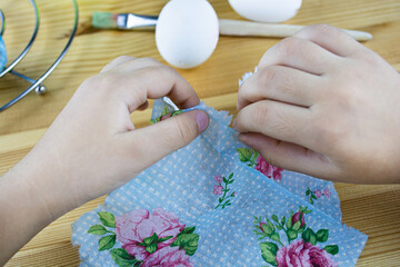 Hands tearing the egg decorating napkin. Decorating Easter eggs with decoupage technique. Step by step, tutorial. Step 2