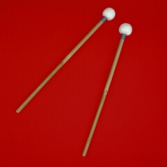 Timpani mallets on a red background.