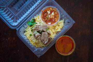Roasted meat served with rice and chillies tamarind sauce and curry gravy in a take out container. Malaysian traditional cuisine, Nasi Daging Utara.