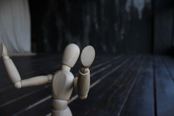 wooden mannequin sitting on the floor