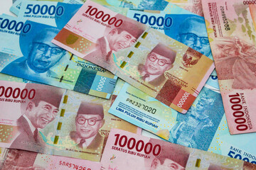 scattered indonesian rupiah. indonesian money. one hundred thousand rupiah and fifty thousand rupiah.