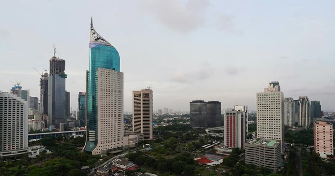 Dramatic day to night time lapse with moon rise over Jakarta downtown modern district in Indonesia capital city, the largest city in Southeast Asia