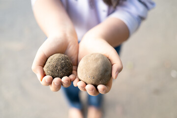 a kid holding Mud balls