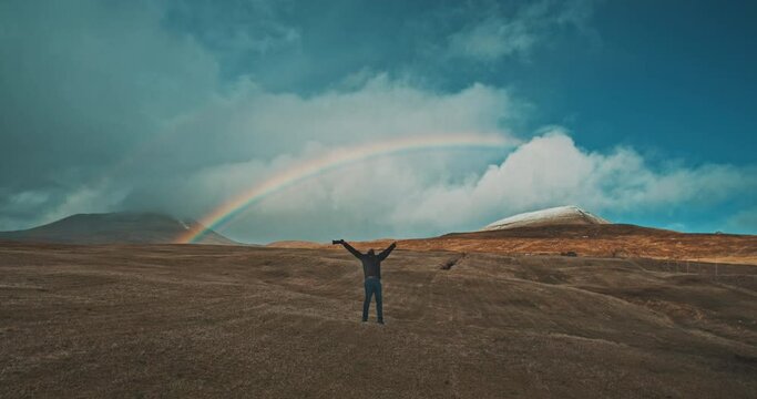 Photographer celebrating under the rainbow