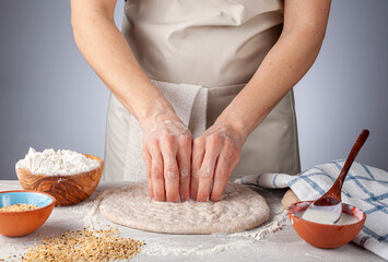 Preparation of homemadeTurkish flat bread, pide or pizza base in the kitchen. A woman chef is making finger nail impressions for the specific traditional Tirnak pidesi recipe.