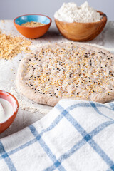 Homemade Turkish Flat bread known as Ramazan Pidesi, Tirnak Pidesi or pide. A hand rolled rounded flat dough with finger nail impressions, yogurt as well as poppy and sesame seed topping. 