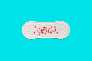 Feminine hygiene photo. Menstrual woman pads for hygiene protection in critical days, cycle blood period concept. Menstruation sanitary and gynecological soft pad with hearts on it. Flat lay, top view