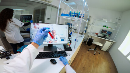 POV of scientist advicing with professional doctor on video call, discussing during virtual meeting in medical laboratory. Chemist examining vaccine evolution using high tech researching treatment