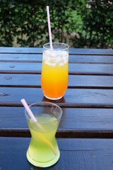 Summer fresh cold drink beverages. Ice Lemonade, orange juice and spirits in glasses  on the table outdoor. Refreshing cocktail. It is called 