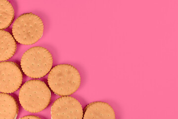 Cream filled sandwich cookies in corner of pink background with empty copy space