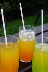 Summer fresh cold drink beverages. Ice Lemonade, orange juice and spirits in glasses  on the table outdoor. Refreshing cocktail. It is called 