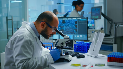 Medical research scientist conducting vaccine development under digital microscope in a biological...