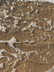 Close-up - water ripples on the sand. The Baltic Sea.