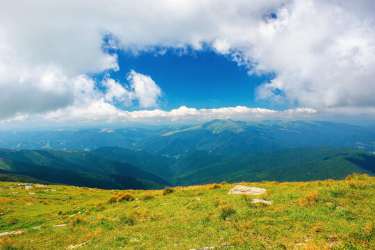 carpathian summer mountain landscape. beautiful countryside with rocks on the grassy hill. view in to the distant valley. clouds on the blue sky. wonderful travel destination