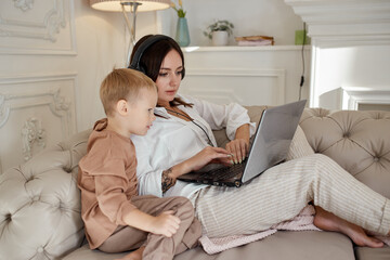 Mom daughter and son play on laptop. Family recreation and leisure