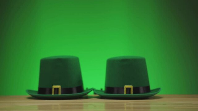 two mugs of green frothy beer clink on a green background St. patrick's day