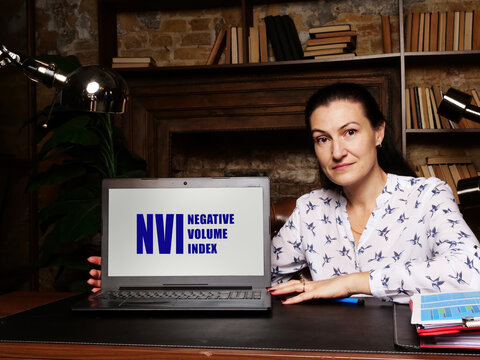 Woman showing laptop computer with  NVI NEGATIVE VOLUME INDEX icon on screen background, success in business concept