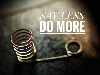 'Say Less, Do More' motivation quote with a spring in blurry background.