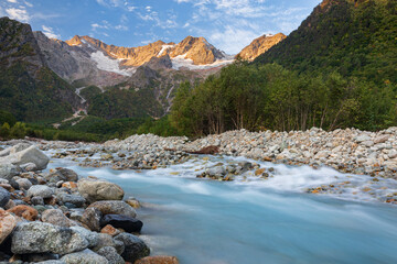 Majestic mountain landscape with river at sunrise. Peaks of the Caucasus Mountains. National Park...