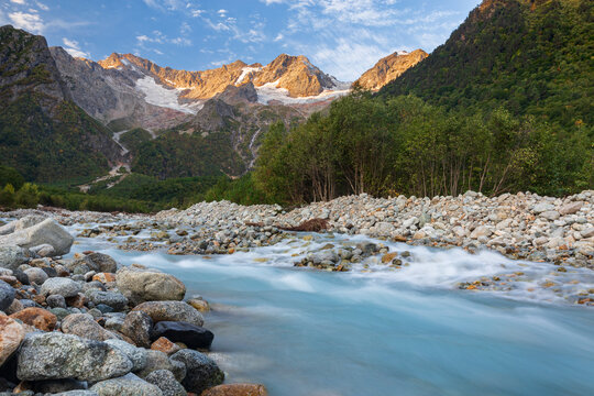 Majestic mountain landscape with river at sunrise. Peaks of the Caucasus Mountains. National Park North Ossetia - Alania