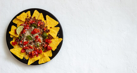 Corn chips nachos with meat, cheese, tomatoes and peppers. Mexican food. National cuisine.