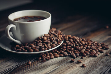 saucer with coffee beans and white cup on a wooden table side view Copy Space