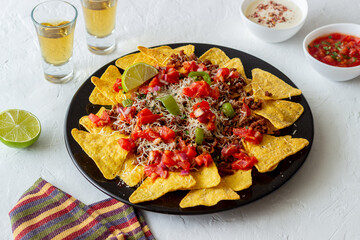 Corn chips nachos with meat, cheese, tomatoes and peppers. Mexican food. National cuisine.