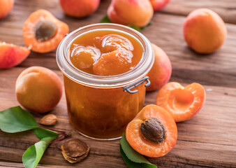 Apricot jam and ripe apricots on the table.