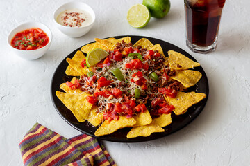 Corn chips nachos with meat, cheese, tomatoes and peppers. Mexican food. National cuisine.