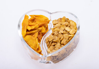 Roasted and salted fava beans and dried mango slices for a healthy vegan and vegetarian diet snack. High in protein, vitamins, dietary fibre and nutrients