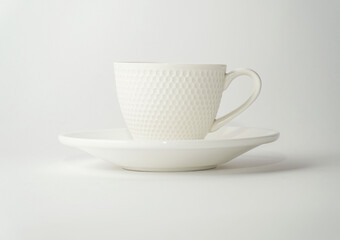 White cup relief surface with saucer on white background.