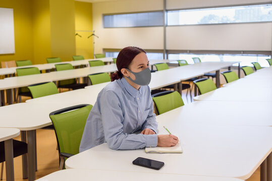 Woman Student In Face Mask In Empty Classroom Of University. Learning New Normal