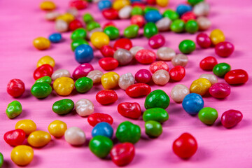 Fototapeta na wymiar Multicolored candies on a pink background.