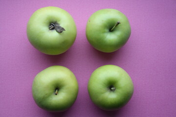Juicy yellow apples on a pink background.
