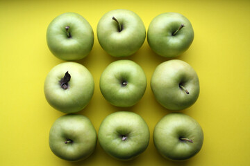 Juicy yellow apples on a yellow background.