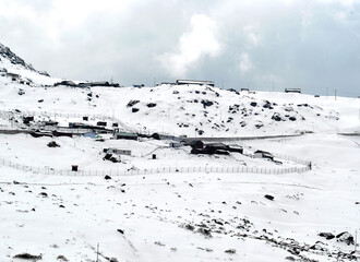 A panoramic of snow-covered terrain and army houses at Tsomgo Lake situated at 12,600 ft altitude in Sikkim. Snow is continuously showering in this are due to the western disturbances.