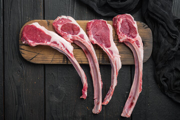 Raw fresh lamb ribs ready for cooking, on black wooden table background, top view flat lay , with...